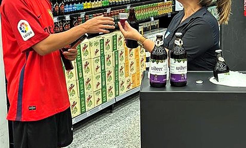 Promotora oferecendo degustação a um cliente