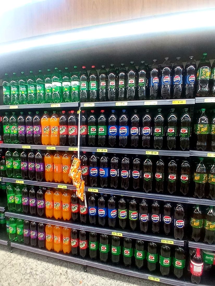 Gôndola de refrigerantes abastecida e organizada por marca e sabor